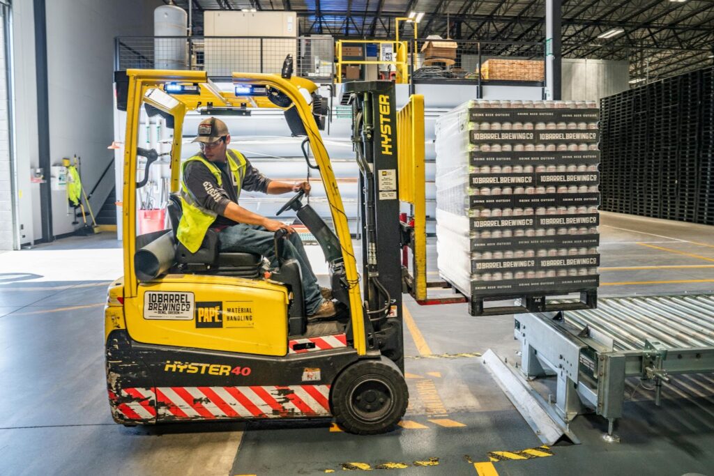 Worker using forklift in a warehouse