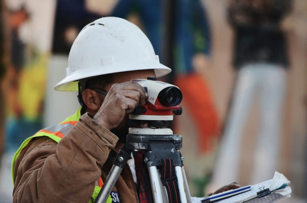 A construction worker using a surveyor on a site.