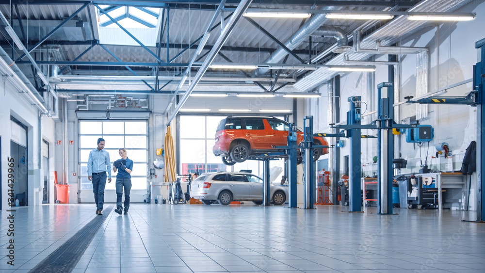 Auto repairer with a client in an auto repair shop