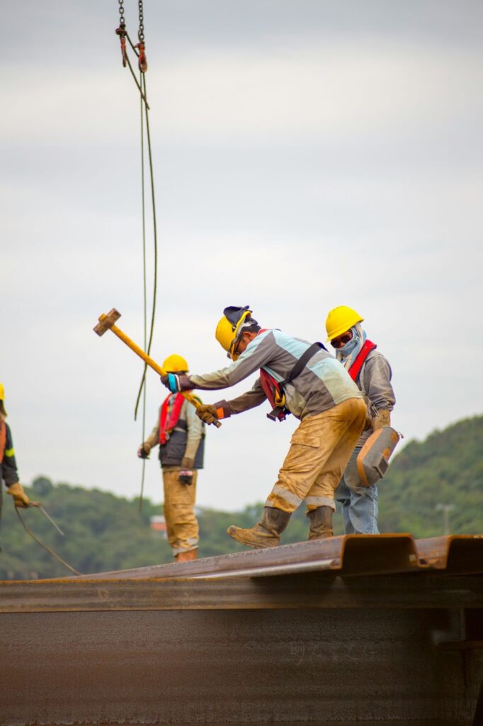 A construction worker holds a hammer on a building site.