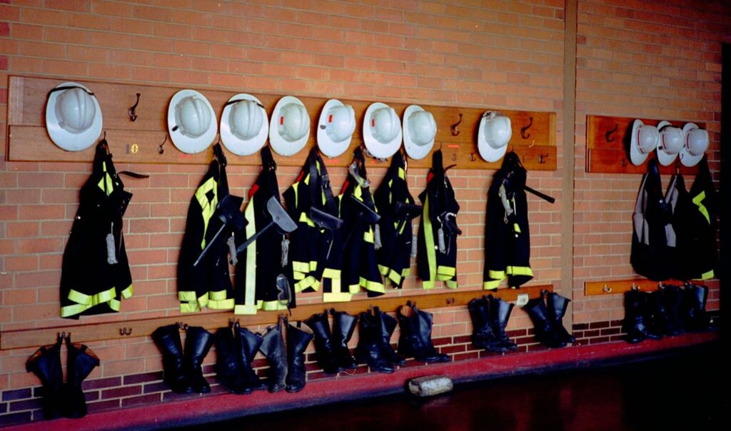 Fire helmets, jackets, and boots at a fire station.