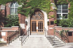 The doorway of a church with steps and handrails.