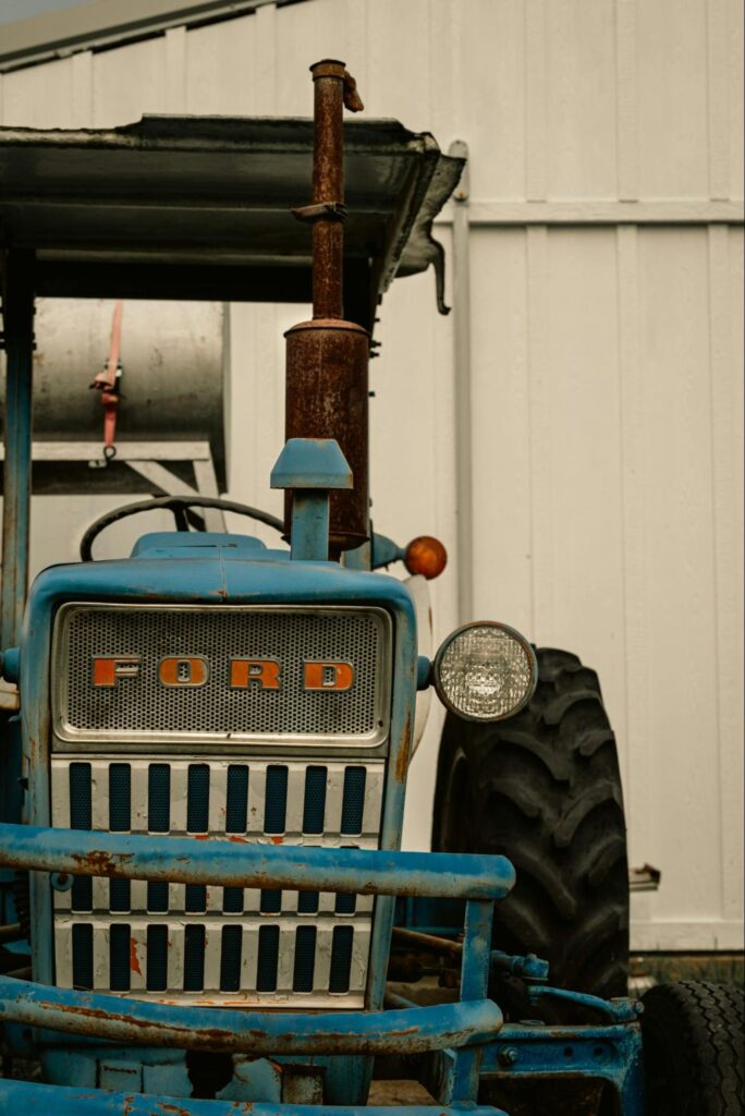 A blue tractor parked in a white garage.