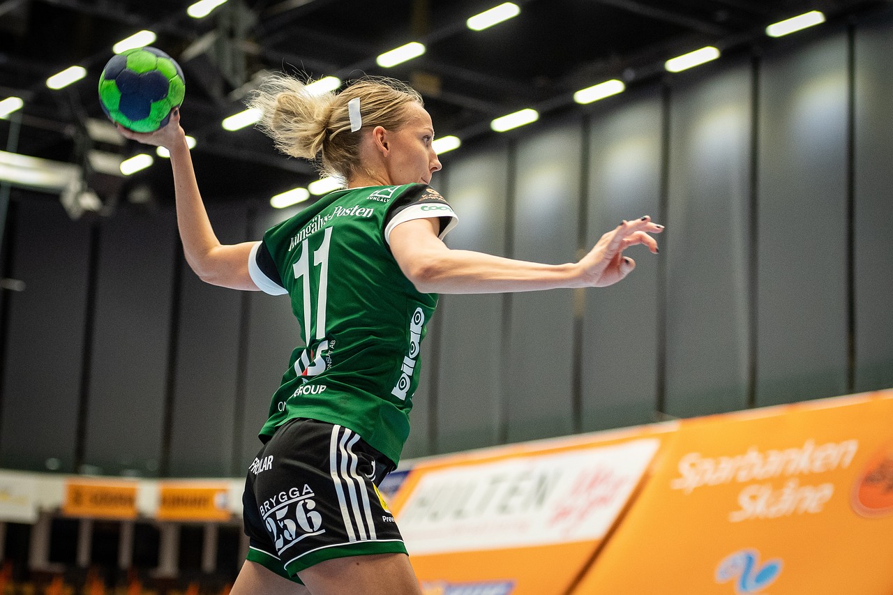 A woman is playing volleyball in an indoor sports facility.