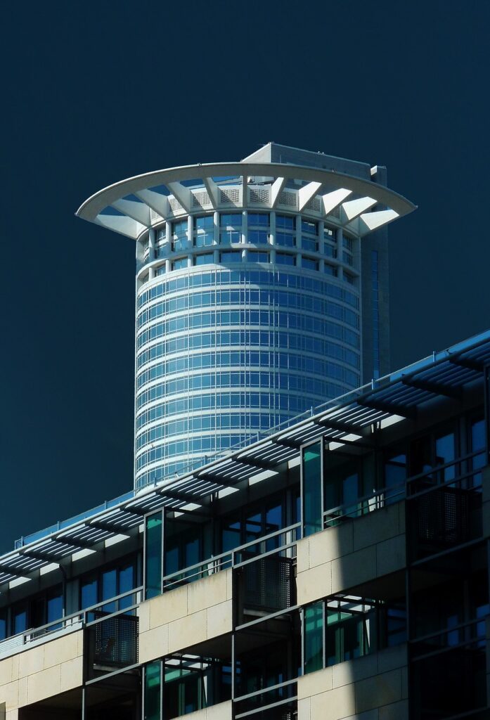 A metal building with a glass and steel tower behind it.